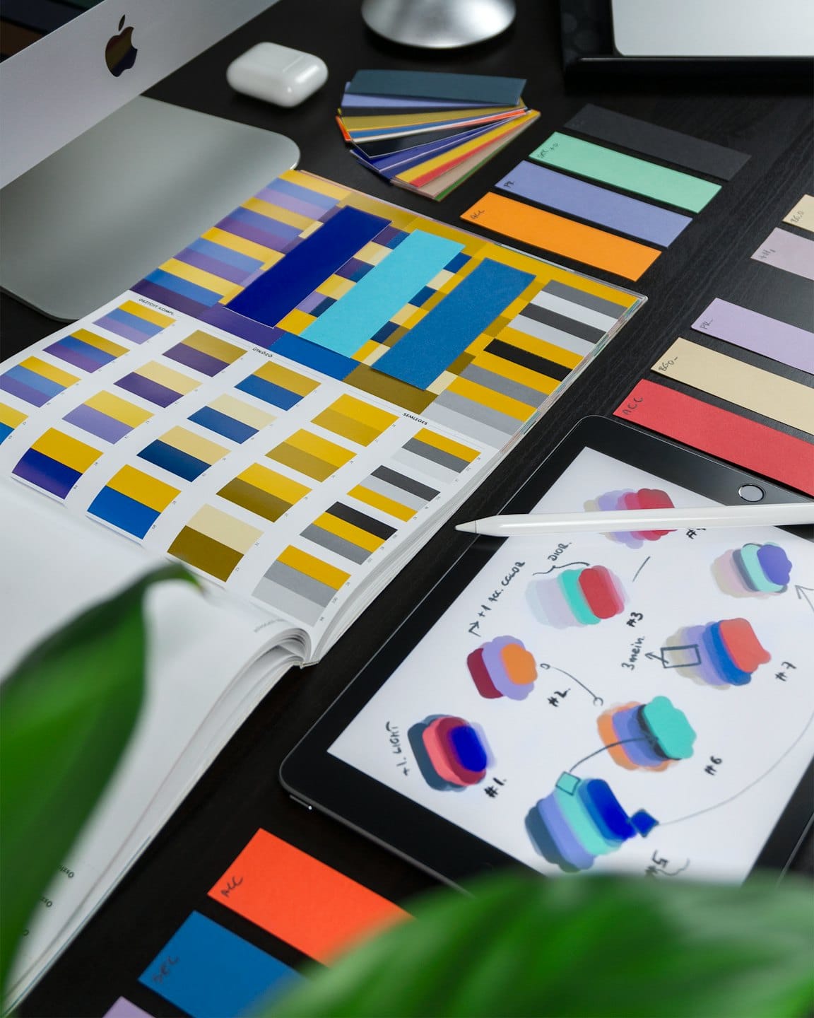 Scrivania di un designer con campioni di colore, iPad e Apple Pencil.